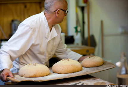 Baker placing bread on wooden board