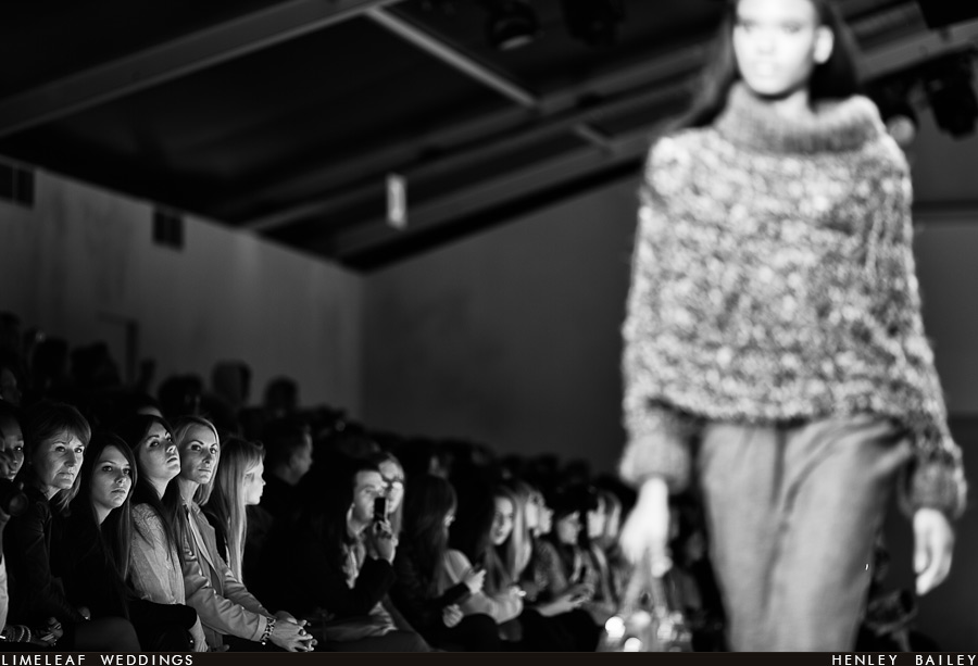 Audience members look on as a model heads down the London Fashion Week catwalk