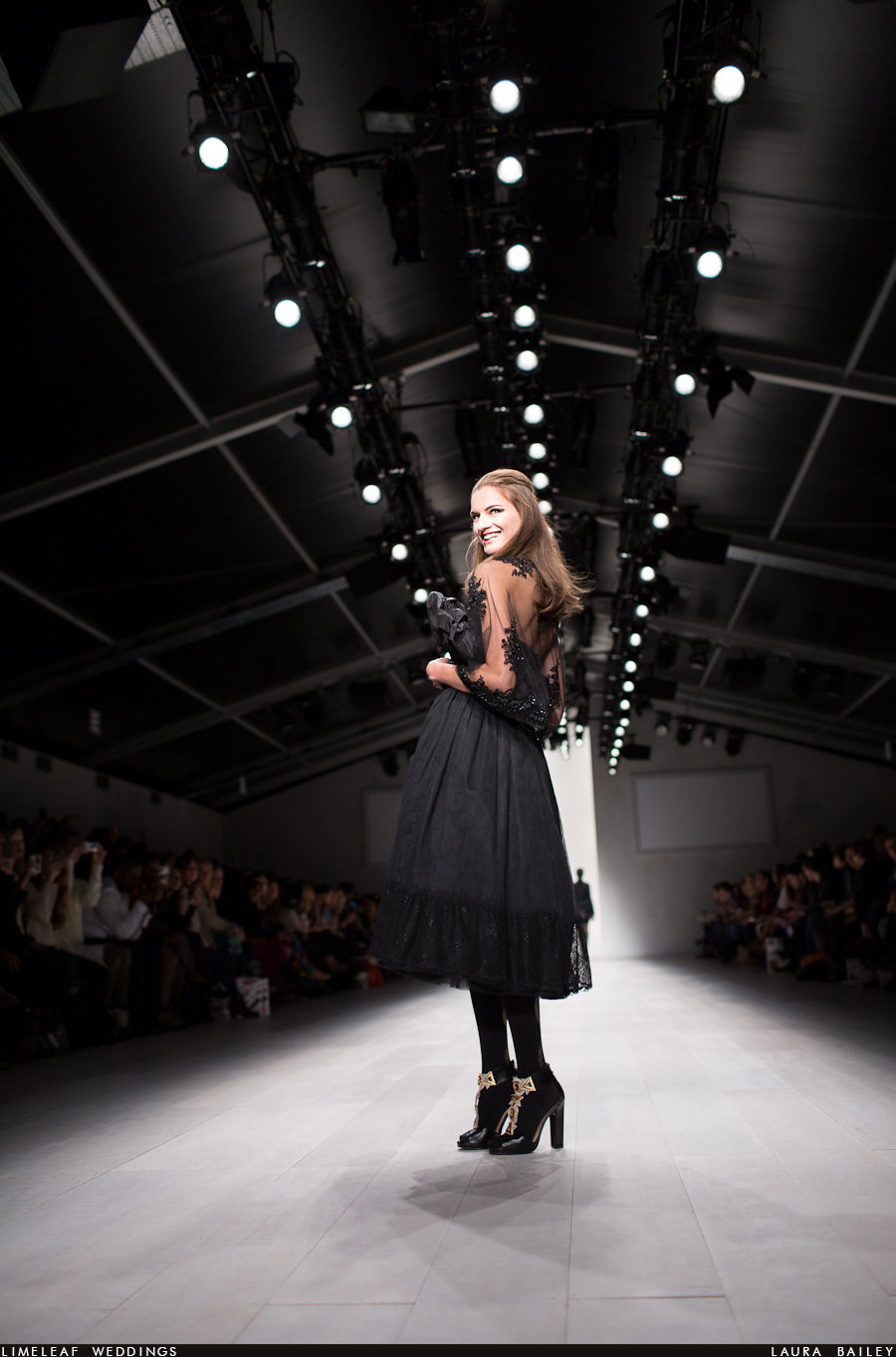 Model turns and smiles at the photographer at fashion week