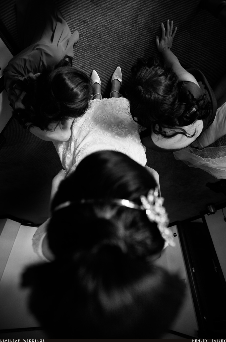 Bride and bridesmaids look at brides shoes