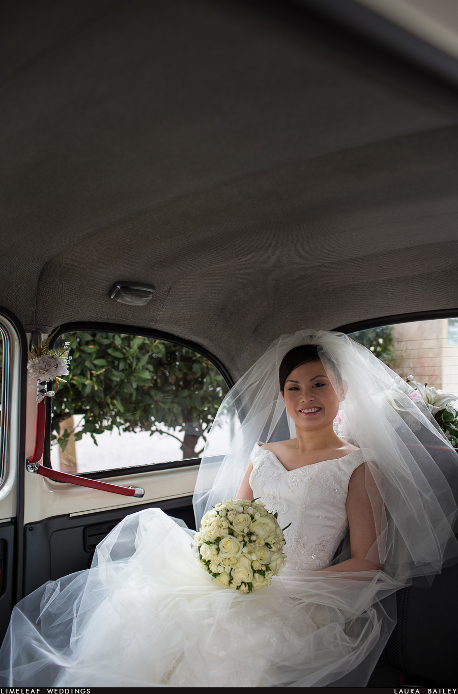 Ashley smiling in London taxi cab before her wedding