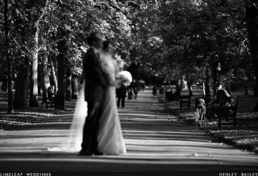 Pedestrian watches bride and groom pose for photo