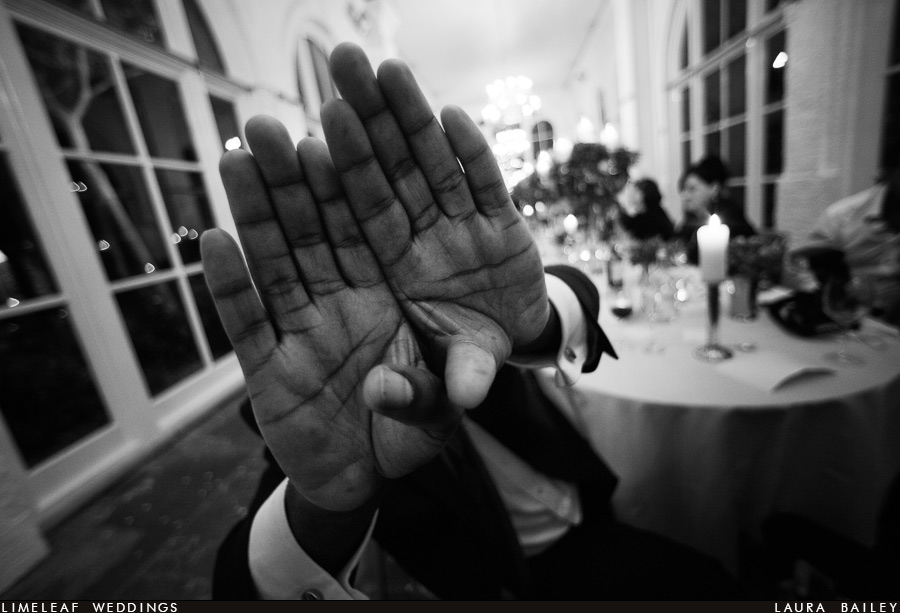 Wedding guest puts hands up in front of camera