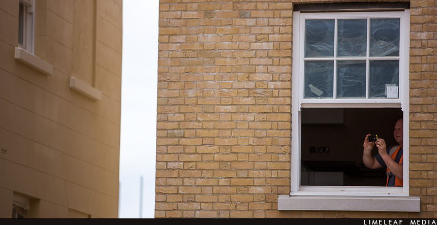 A builder takes a photo from a nearby building