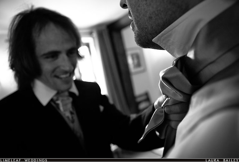 Groomsmen help each other tie wedding kravat
